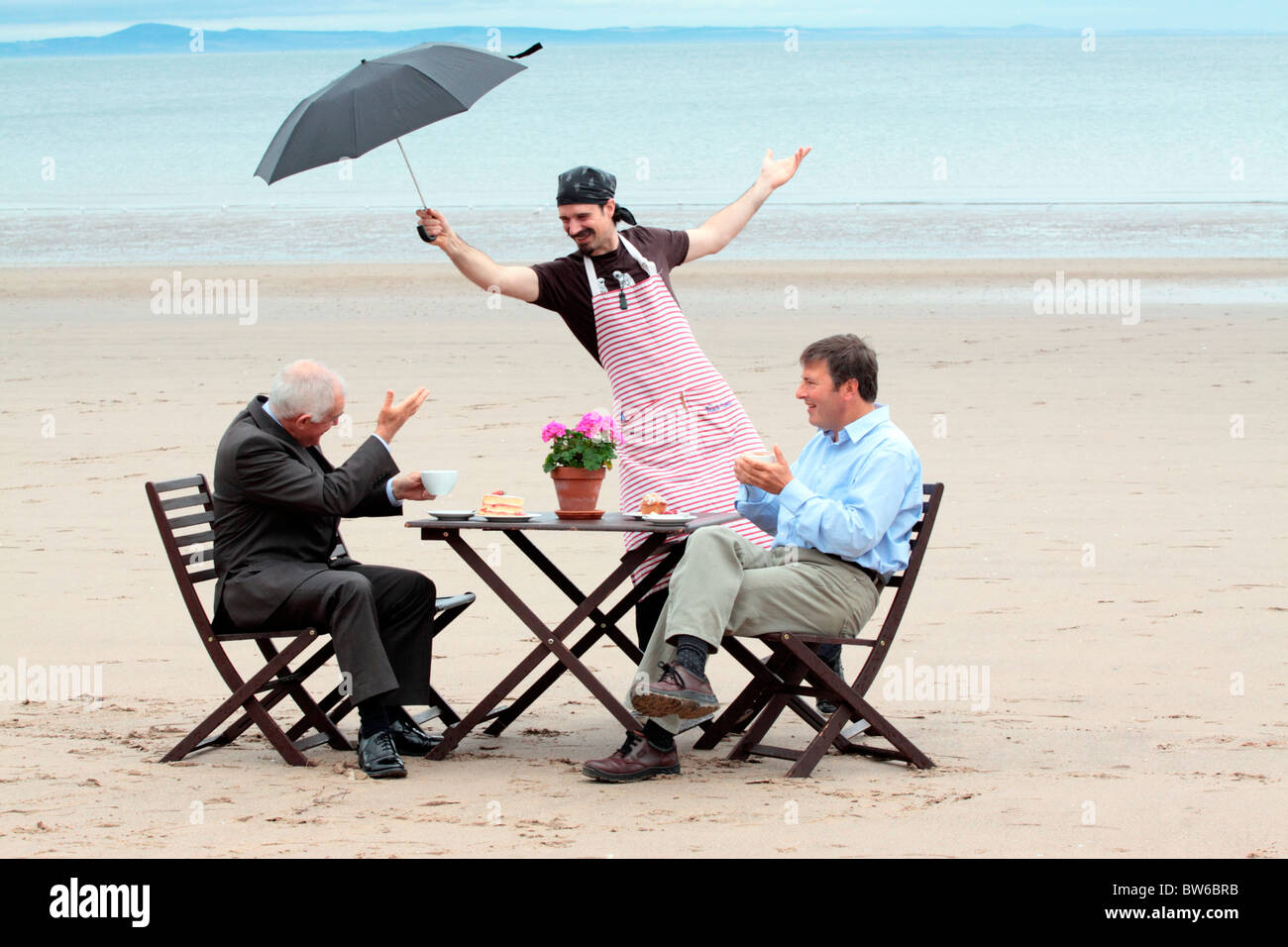 Garçon James Murray détient la pluie La culture écossaise Ministre Jim Mather à la plage de Portobello avec Jonathan Bendit Banque D'Images