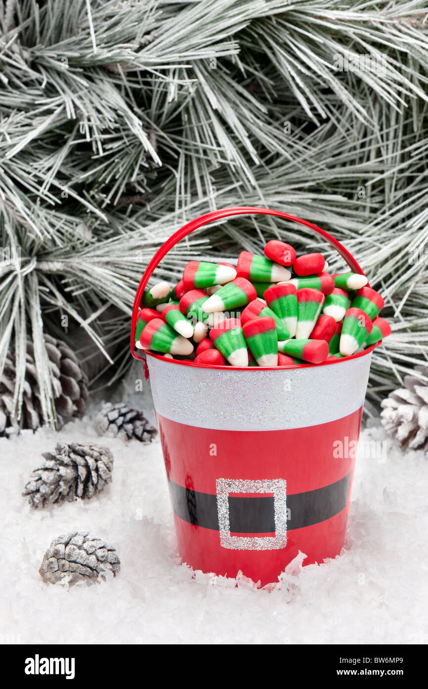 Un seau de bonbons de Noël décorative dans un désert de neige. Espace ouvert pour copier intentionnellement laissé dans le coin supérieur droit de l'arborescence. Banque D'Images