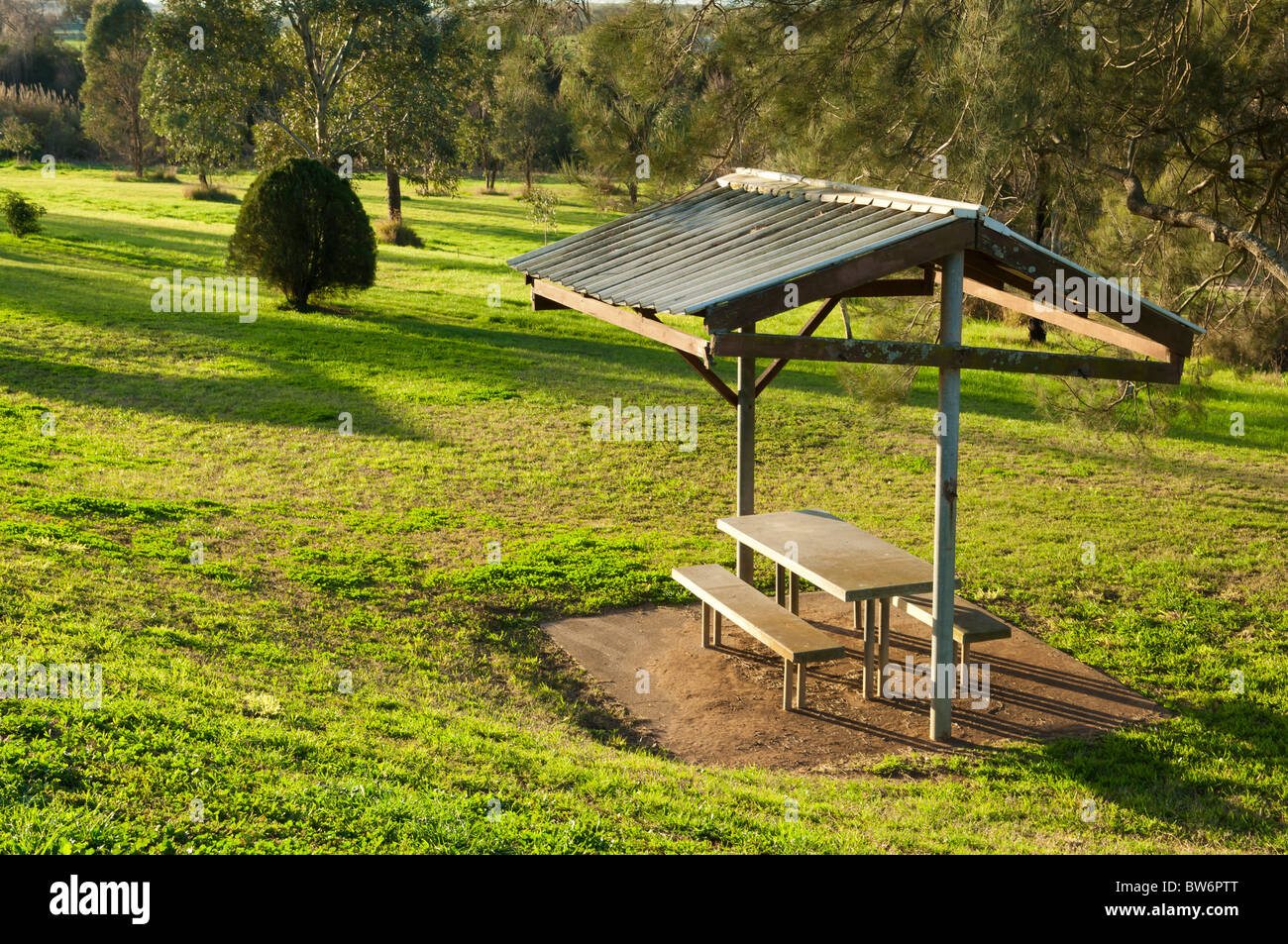 Petit abri dans parc de verdure avec des sièges et une table Banque D'Images