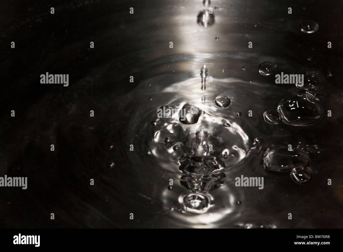 Frapper des gouttelettes de surface de l'eau. Banque D'Images