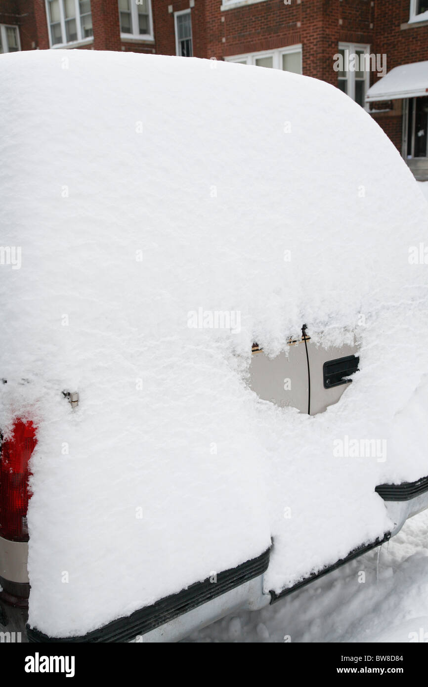 Entoure de neige et couvre un SUV voiture garée sur une rue latérale de la ville en hiver Banque D'Images