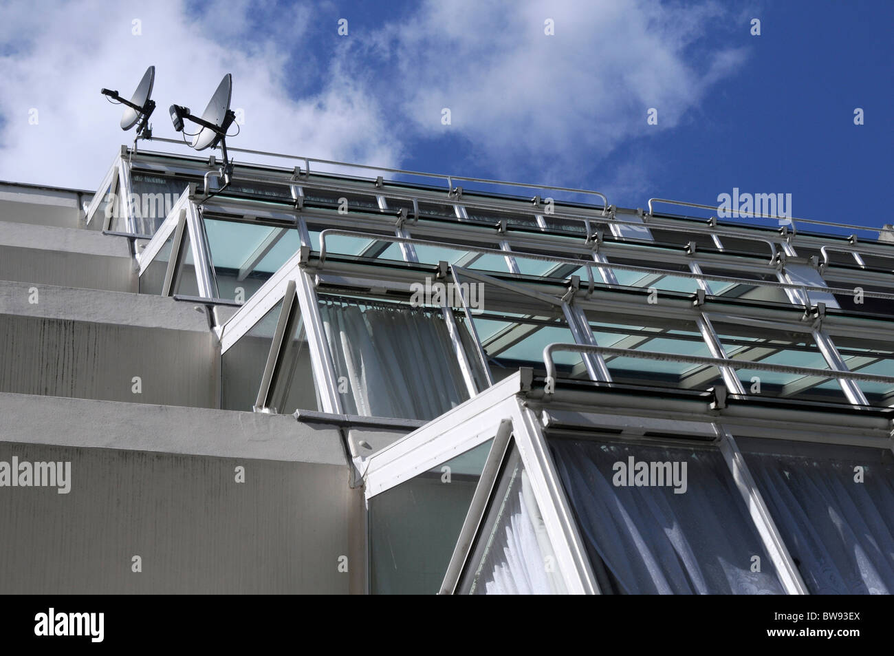 Deux paraboles attaché à l'extérieur des fenêtres de l'appartement Banque D'Images