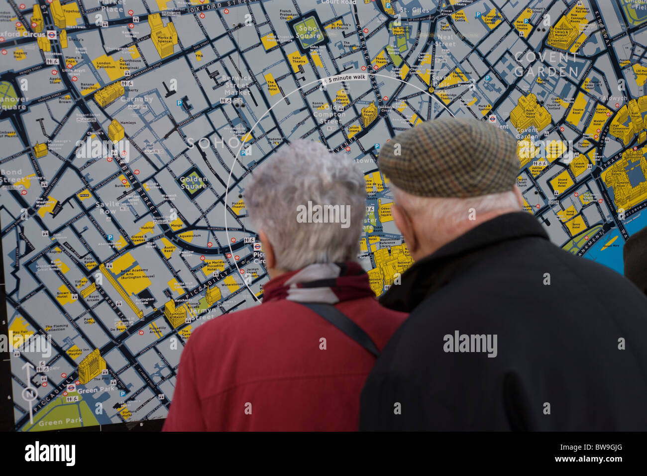 Couple de personnes âgées les visiteurs à central London district de Soho, inspection carte touristique à Leicester Square. Banque D'Images