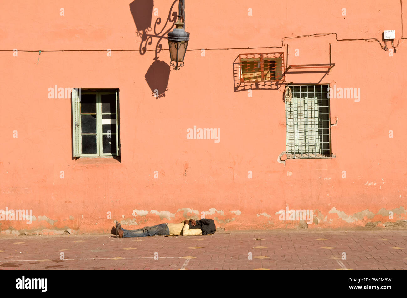 Pose de l'homme endormi sur le pavé à Marrakech, Maroc, Afrique du Nord Banque D'Images