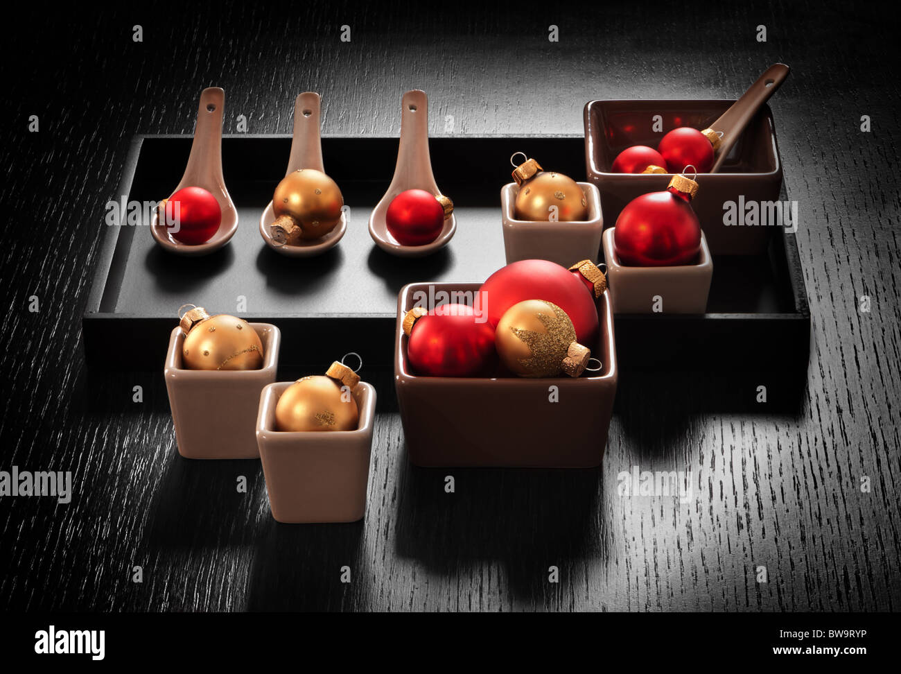 Noël ou Nouvel an décoration : vaisselle apéritif avec bille de verre ornements sur fond sombre. Banque D'Images