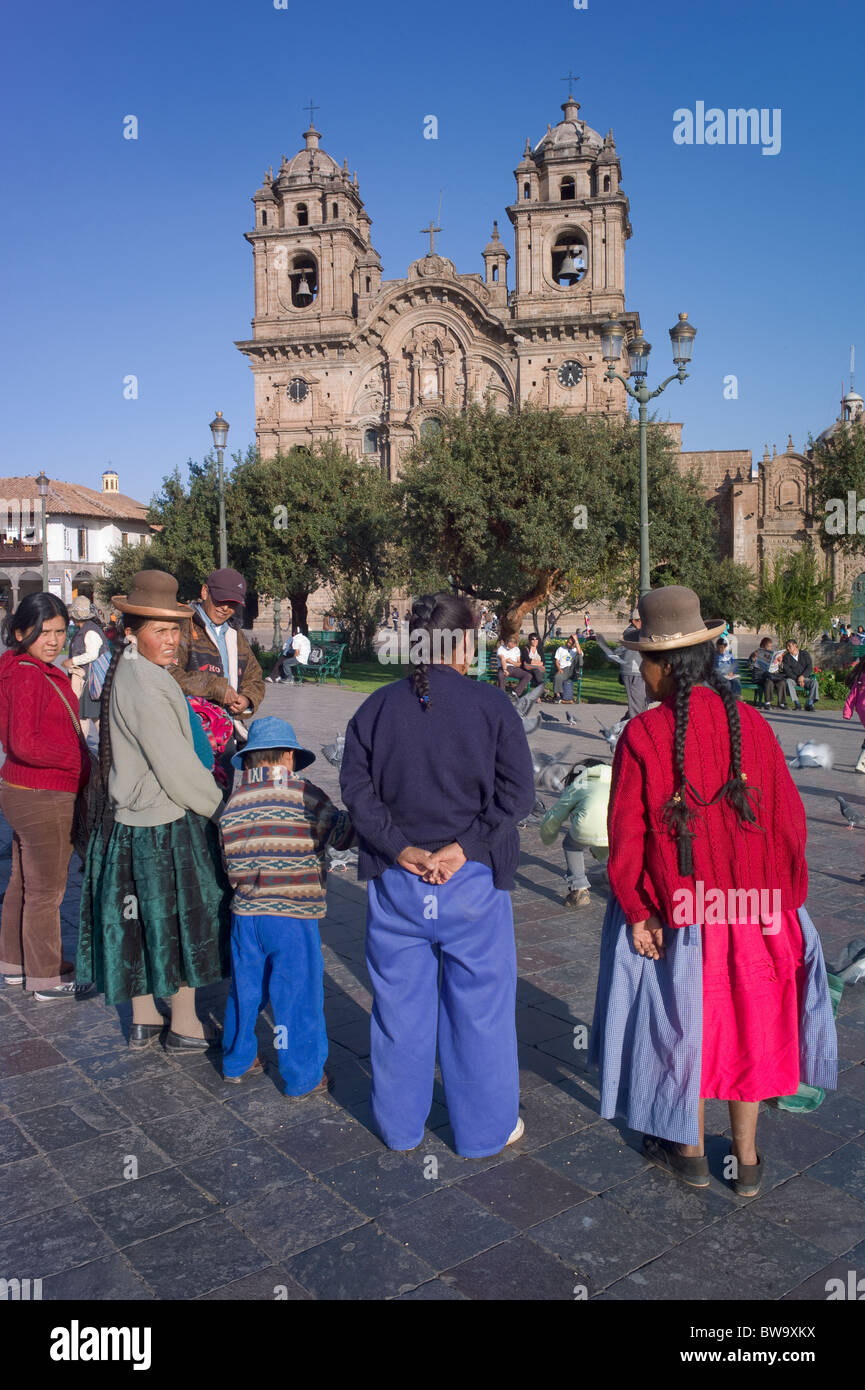 Famille autochtone sur la Plaza de Armes, l'église de la Compagnie de Jésus, Cuzco, Pérou Banque D'Images
