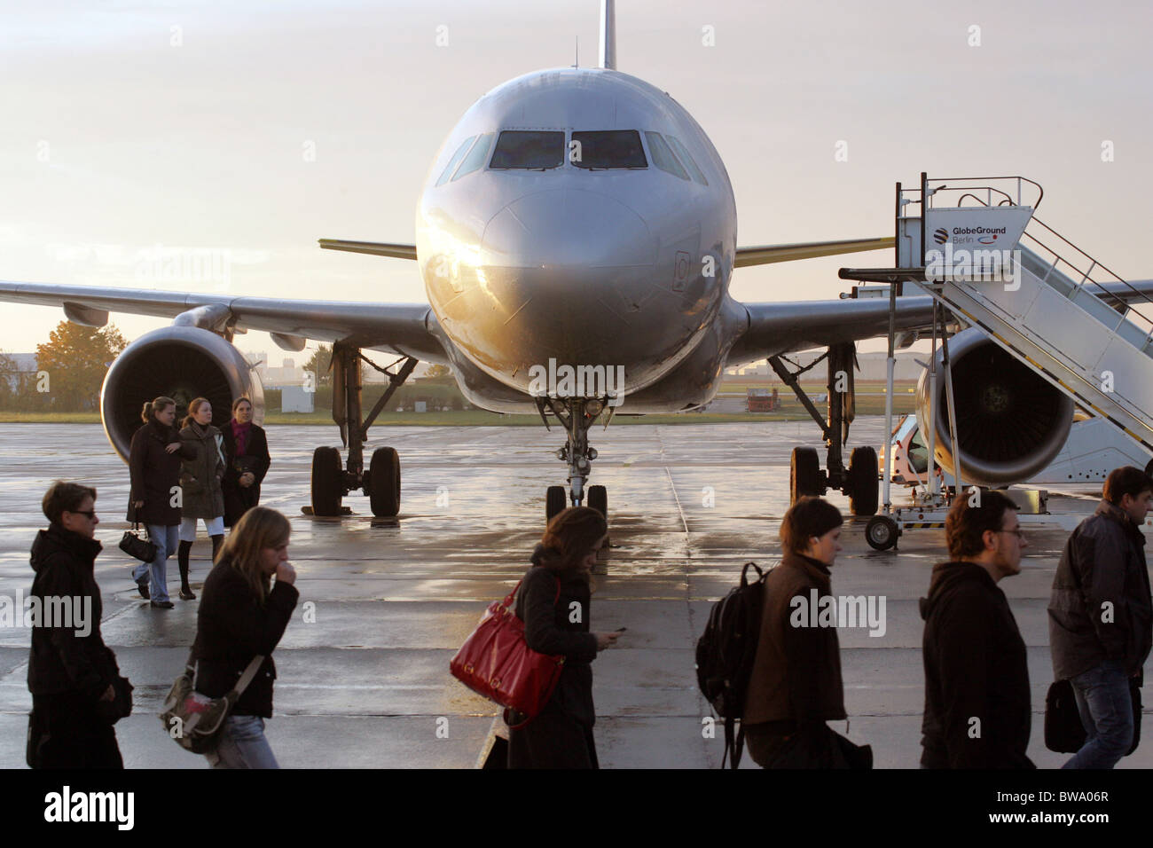 L'avion et les passagers sur l'aire de manœuvre de l'aéroport de Berlin-Schoenefeld, Allemagne Banque D'Images