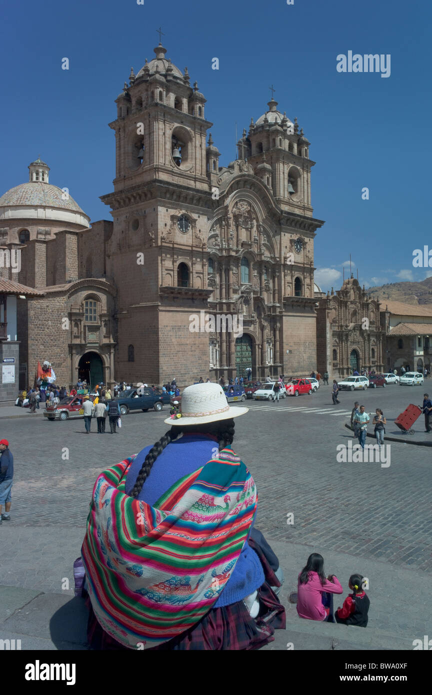 Femme autochtone portant costume assis, l'église de la Compagnie de Jésus, Place de Ville, Cuzco, Pérou Banque D'Images