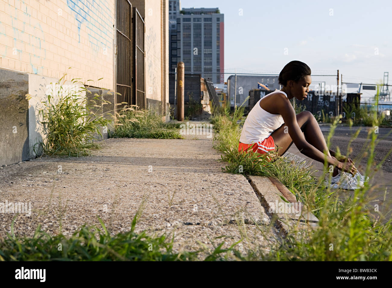 Runner assis sur un trottoir Banque D'Images