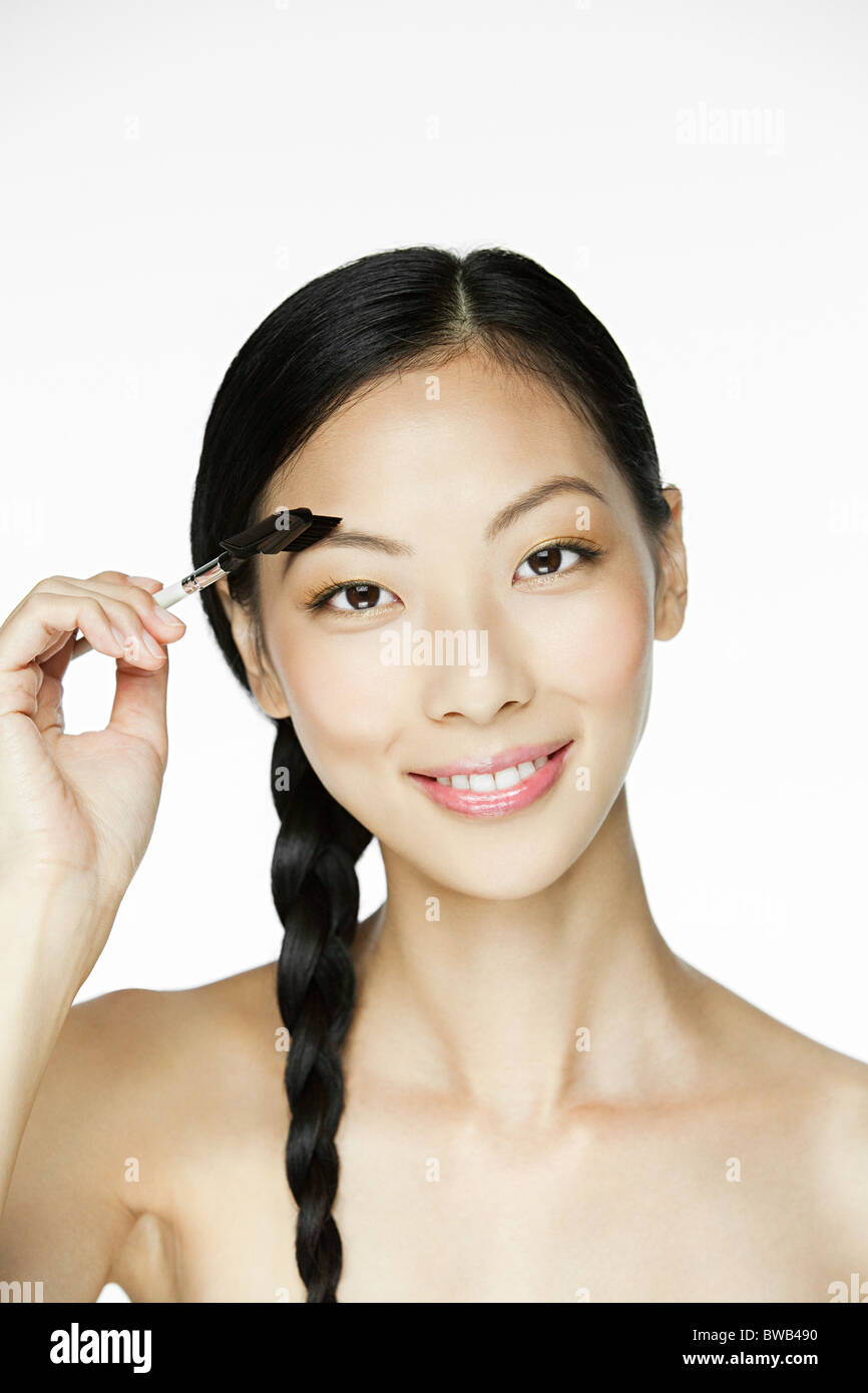 Young woman using eyebrow comb Banque D'Images