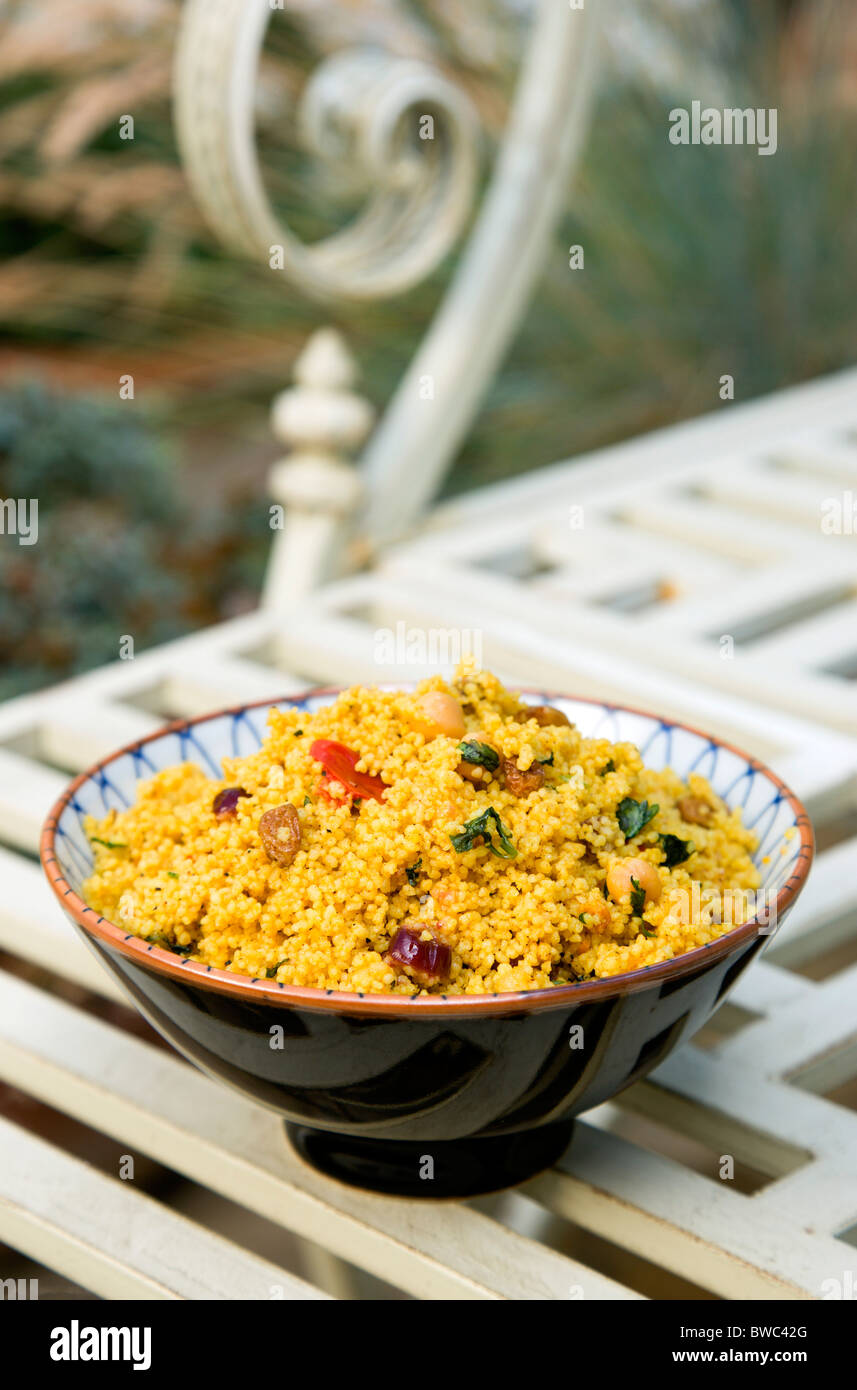 La nourriture, cuit, pâtes, Bol de couscous marocain avec des fruits de noix et de légumes sur une table en métal dans un jardin. Banque D'Images