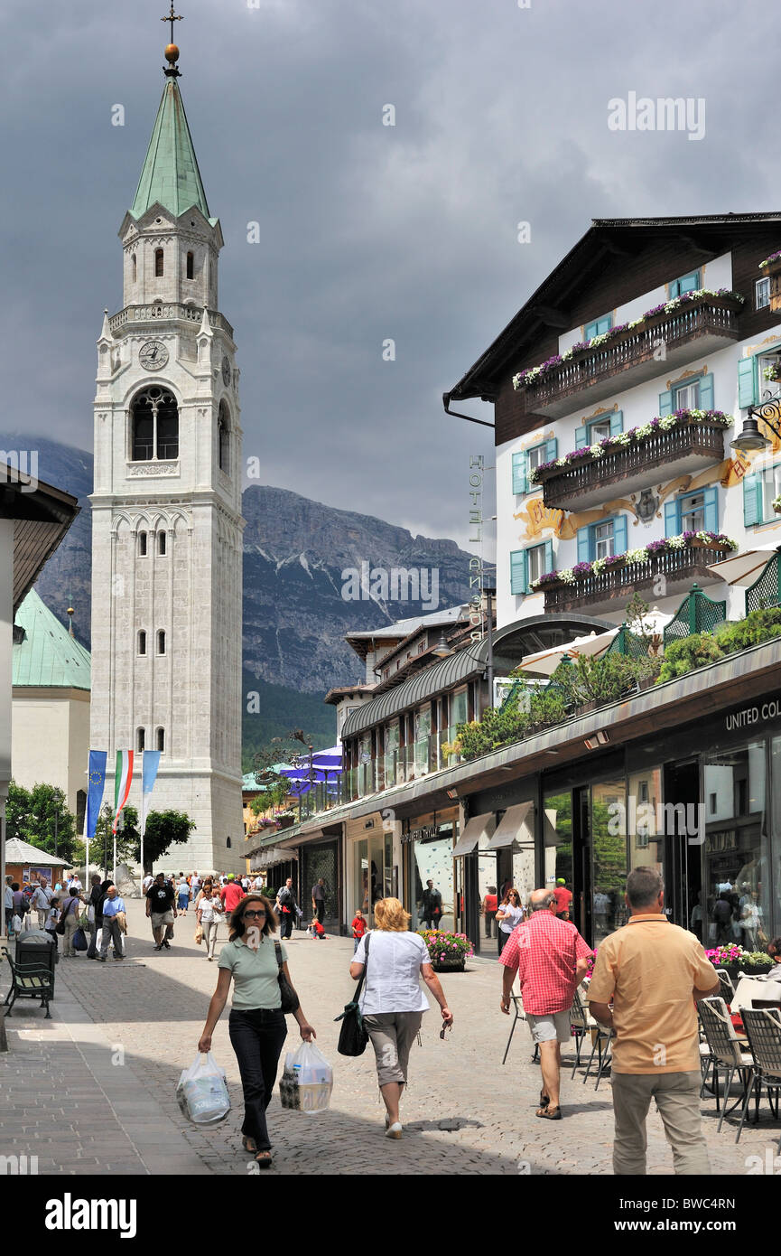 Rue commerçante et l'église paroissiale de Cortina d'Ampezzo, Dolomites, Italie Banque D'Images