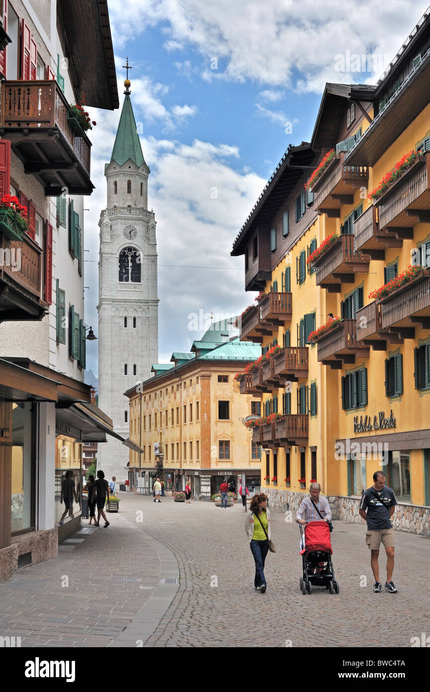 Rue commerçante et l'église paroissiale de Cortina d'Ampezzo, Dolomites, Italie Banque D'Images