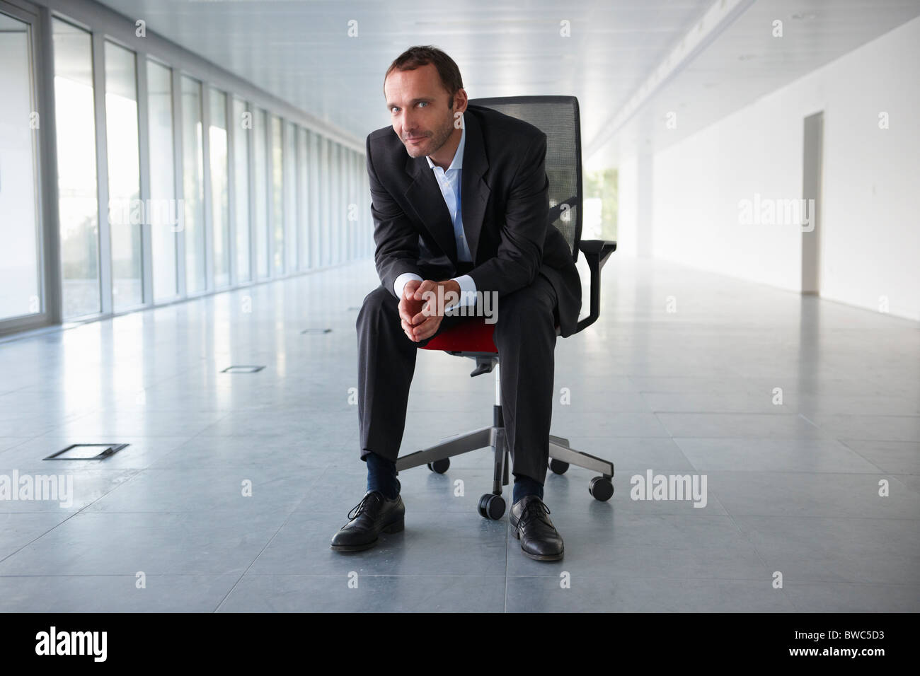 Homme d'affaires sur une chaise, en bureau vide Banque D'Images