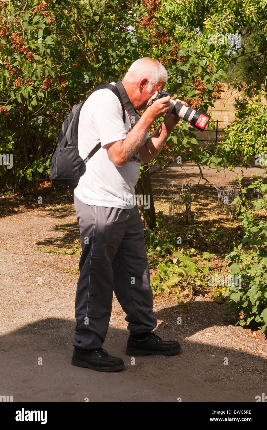 Un homme à prendre des photos avec un appareil photo numérique reflex numérique au Royaume-Uni Banque D'Images