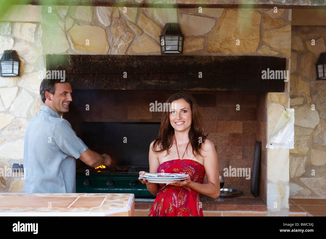 Smiling couple standing par barbecue Banque D'Images Smiling couple standing par barbecue Banque D'Images