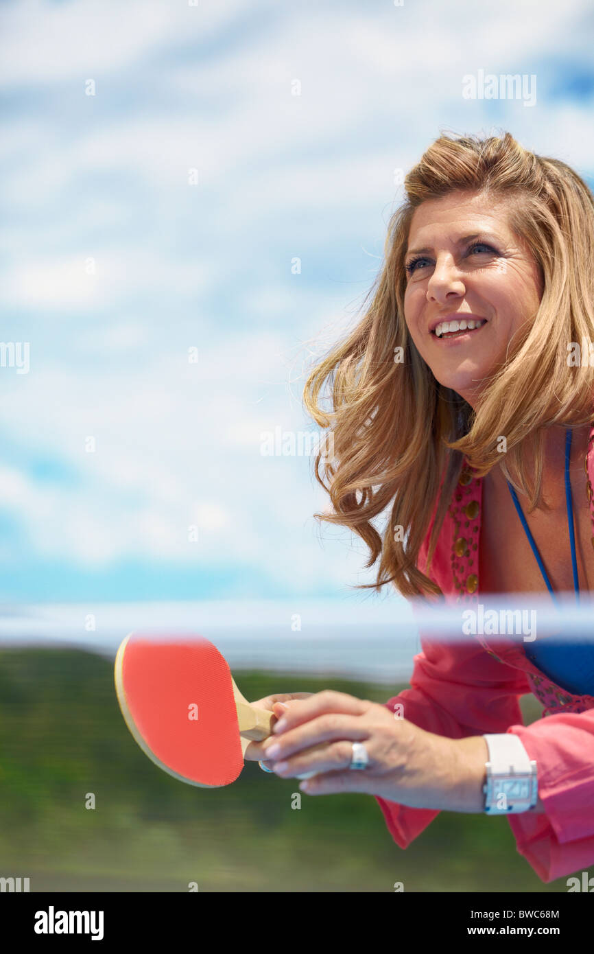 Smiling older woman playing tennis de table Banque D'Images
