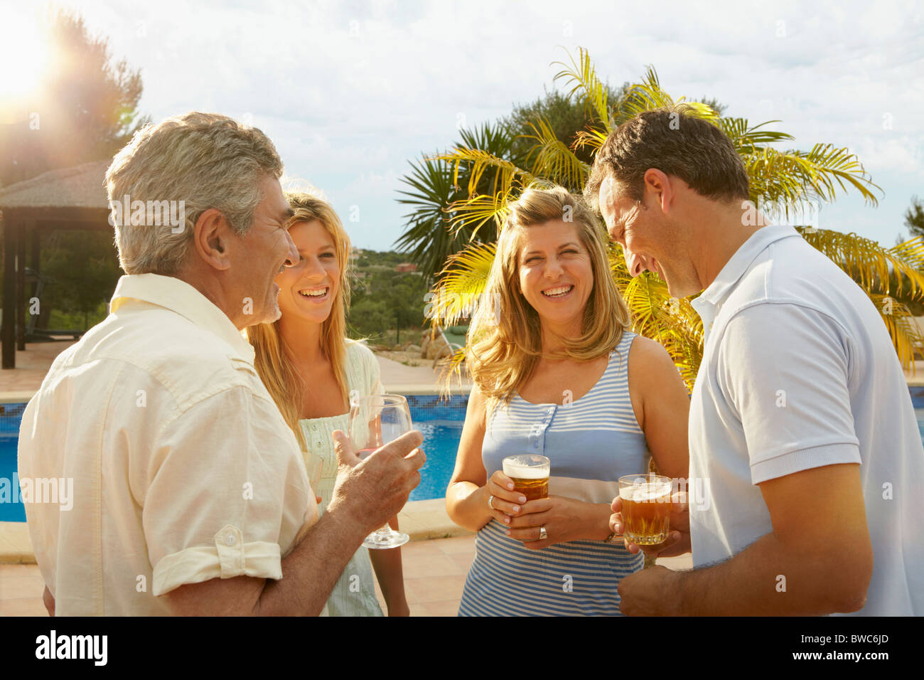 Groupe de personnes ayant un verre à la piscine Banque D'Images Groupe de personnes ayant un verre à la piscine Banque D'Images