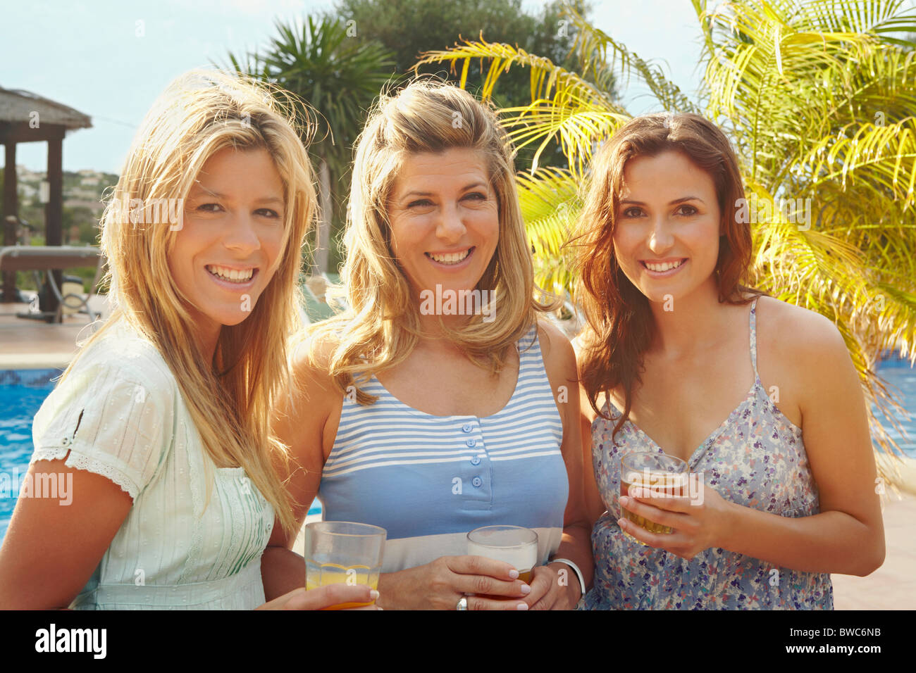Portrait de trois femmes smiling by pool Banque D'Images Portrait de trois femmes smiling by pool Banque D'Images