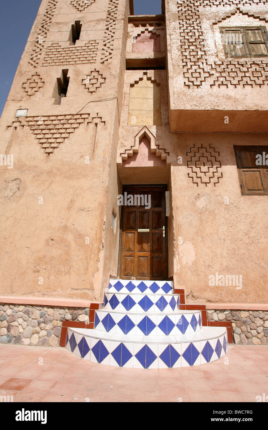 Sol carrelé de couleur marches menant à une porte en bois dans une ville marocaine Banque D'Images