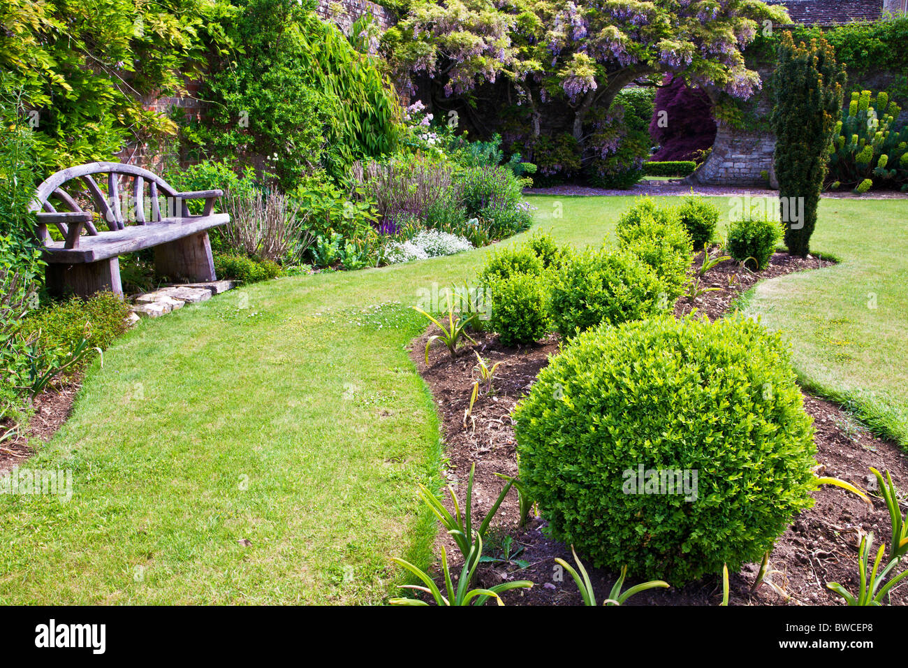Une frontière ondulée et plant bed situé dans une pelouse d'un jardin de campagne anglaise en été Banque D'Images