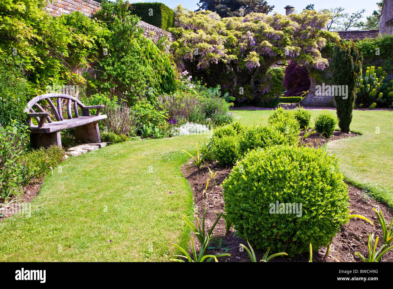 Une frontière ondulée et plant bed situé dans une pelouse d'un jardin de campagne anglaise en été Banque D'Images