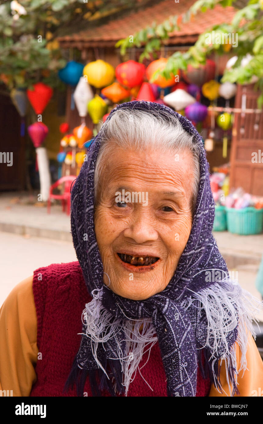 Vieille dame sourit avec dents tachées de bétel dans Hoi An, Vietnam Banque D'Images