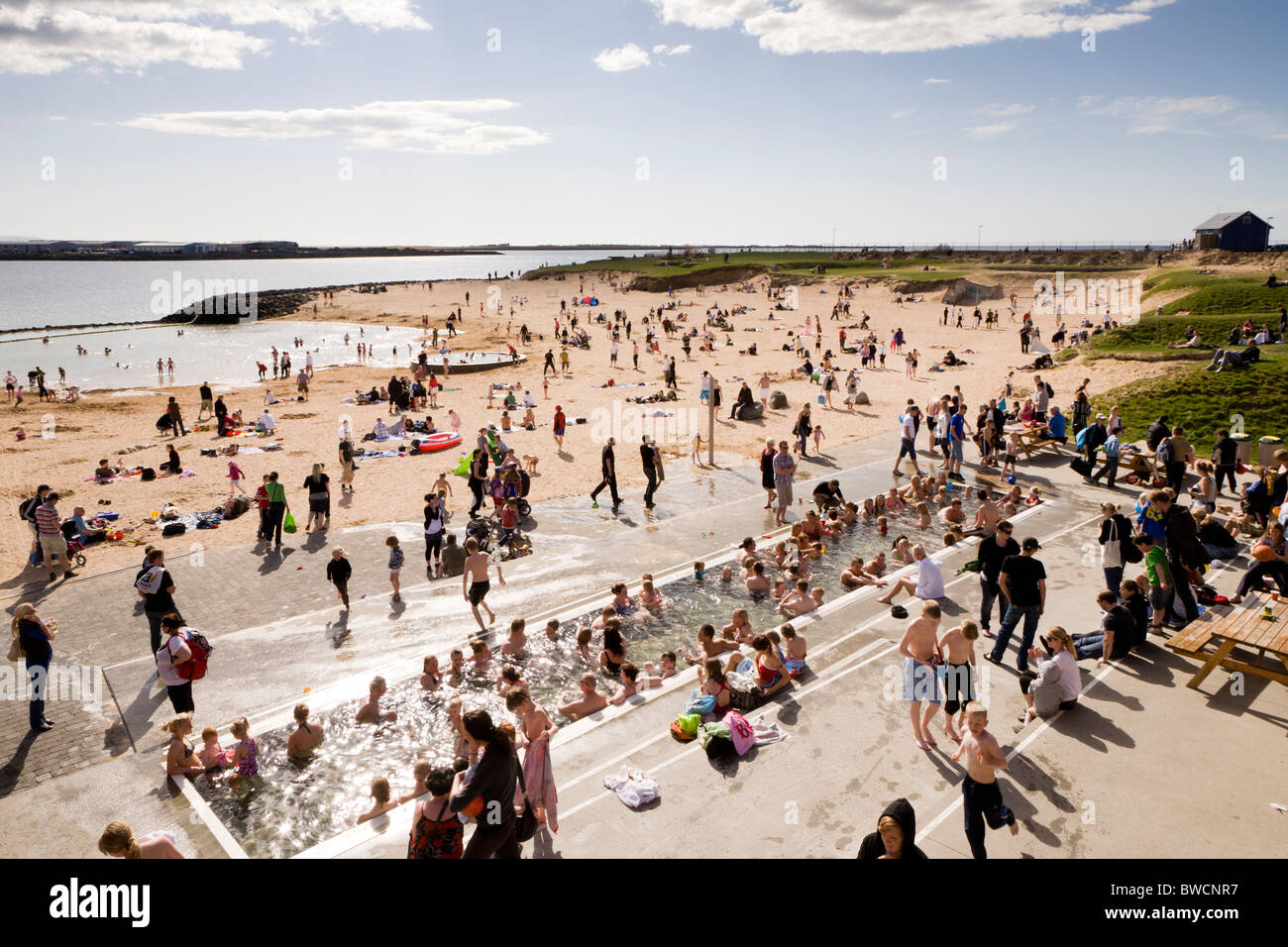 Les personnes bénéficiant de la journée à la plage de Nautholsvik, Reykjavik en Islande. L'eau dans le lagon est chauffée à l'aide de l'eau géothermale. Banque D'Images