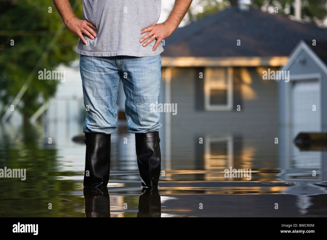 États-unis, Illinois, Chillicothe, Mid adult man standing dans l'eau dans des bottes en caoutchouc, Mid section Banque D'Images
