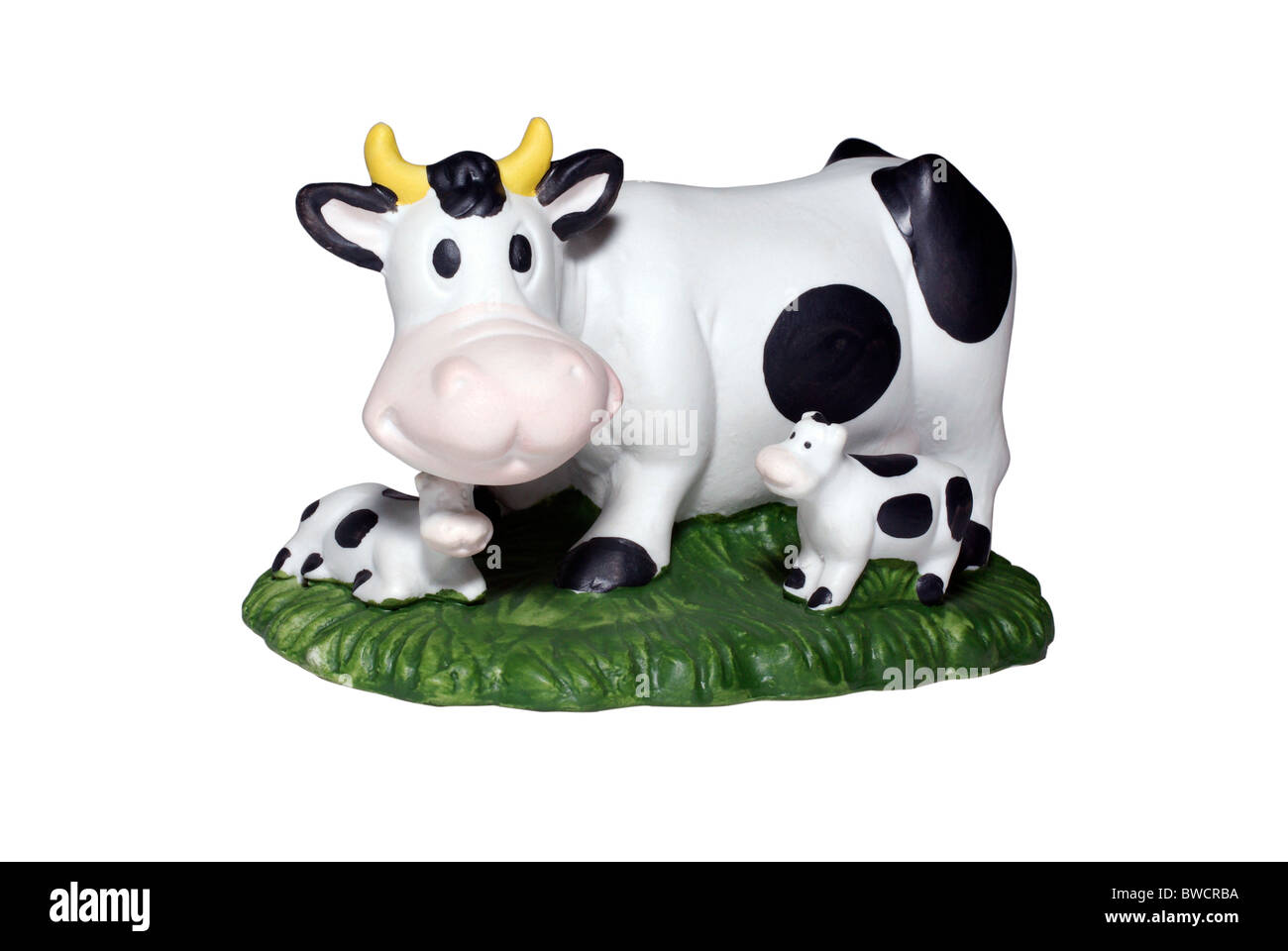Veau vache et deux sur pelouse verte jouet. Isolé sur fond blanc. Chemin de détourage. Banque D'Images