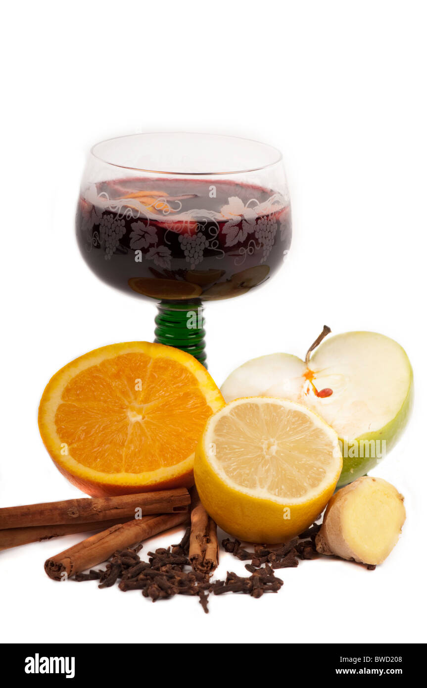 Vin chaud dans un verre entouré par les ingrédients : orange, citron, cannelle, girofle, gingembre, apple. Banque D'Images