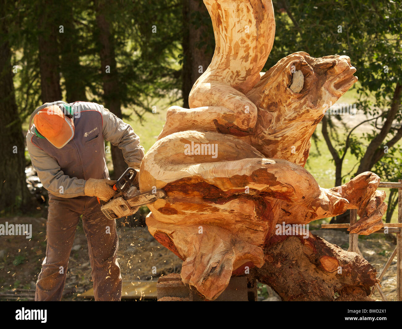 Artiste sculpteur la création d'une sculpture en bois à l'aide d'une scie à chaîne. Les Orres, Hautes Alpes, France Banque D'Images