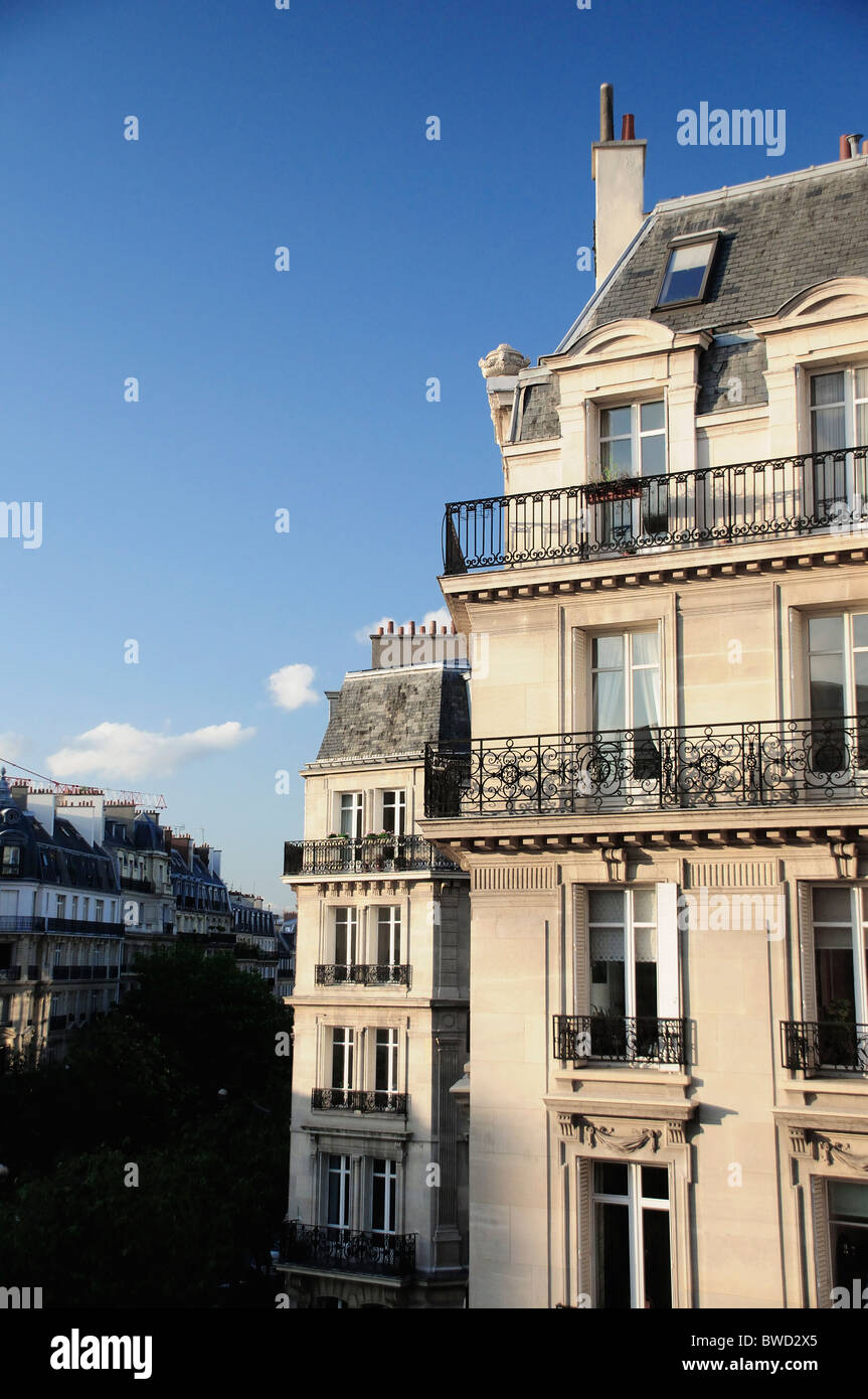 Paris appartement bloc dans la lumière du soleil de l'après-midi avec ciel bleu clair Banque D'Images