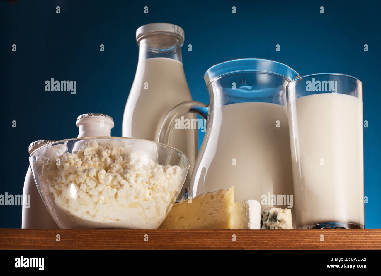 Différents produits laitiers : fromage, crème, lait, yaourt. Sur un fond bleu. Banque D'Images