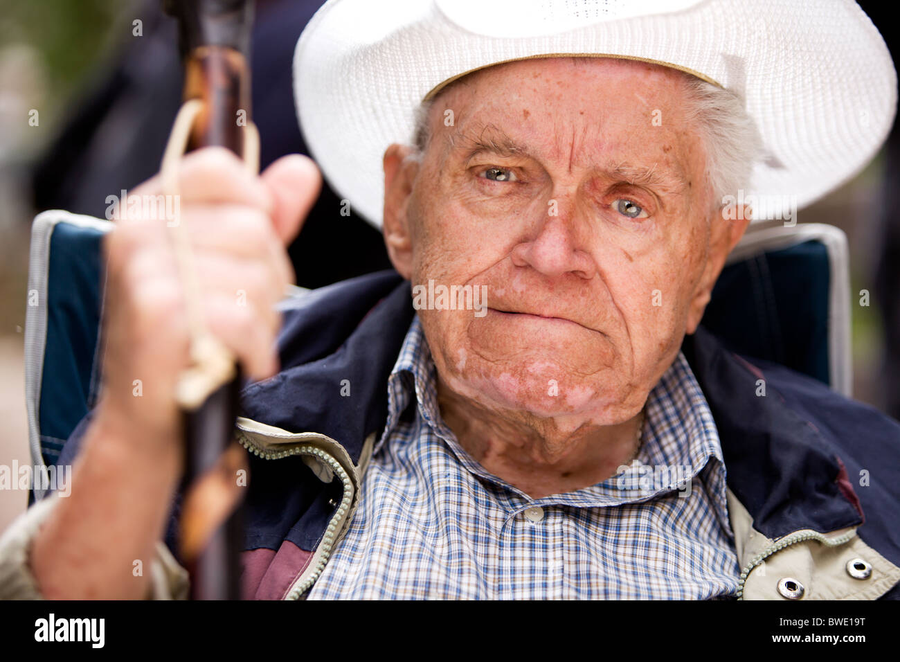 Un portrait d'un vieil homme grincheux assis sur une chaise Banque D'Images