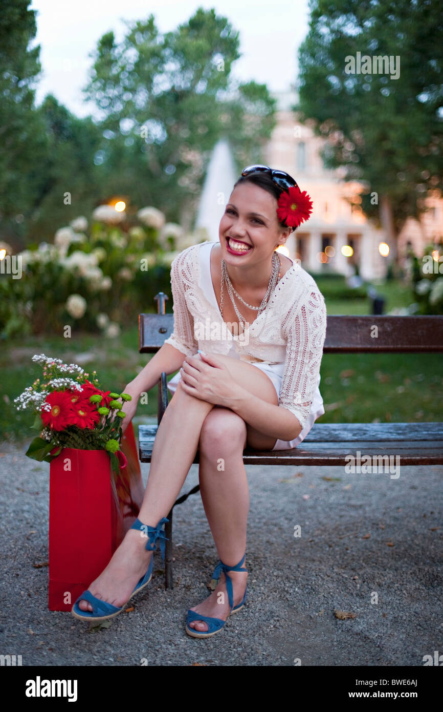 Jeune femme sur le banc de parc Banque D'Images