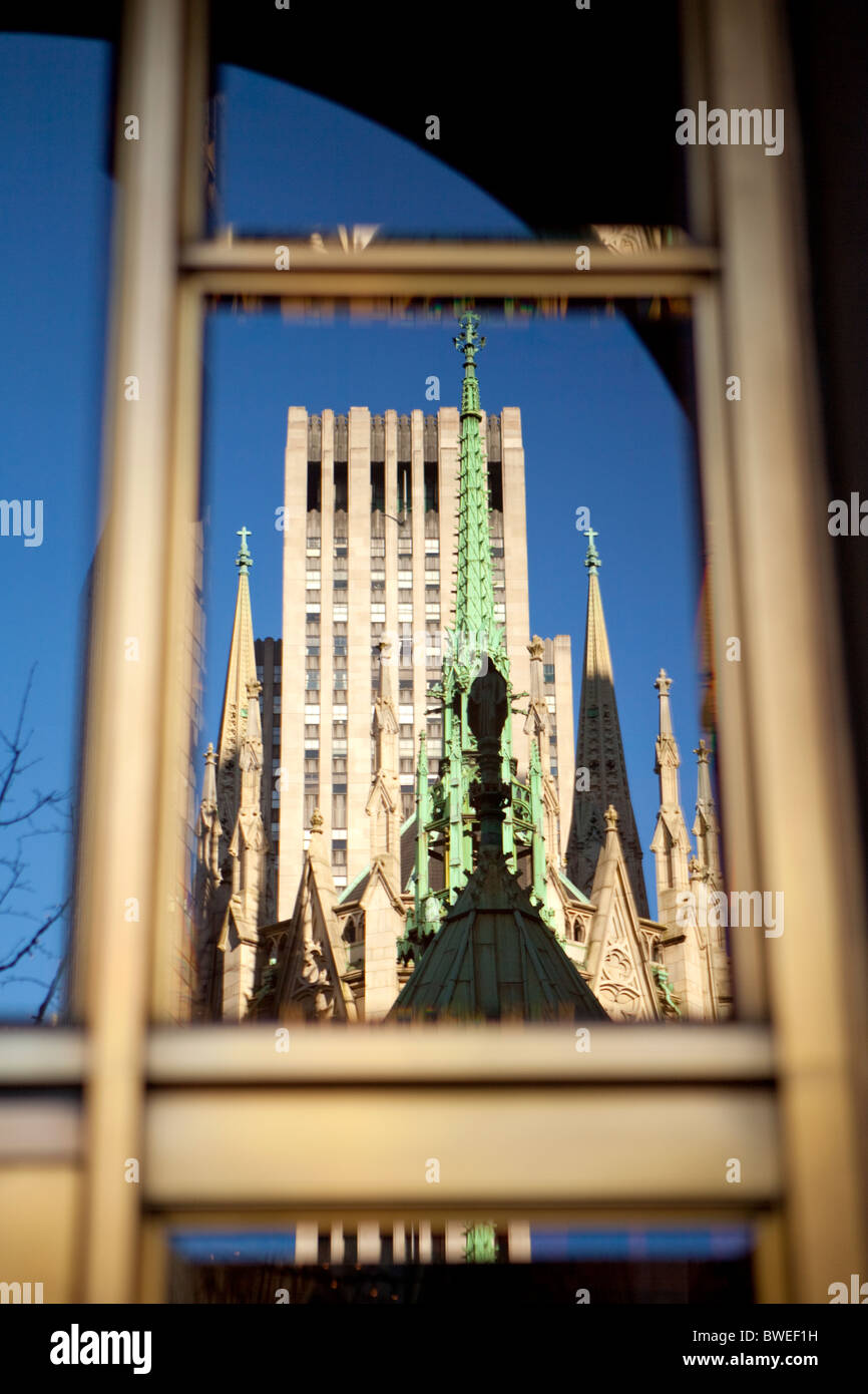 Statue du Christ de cuivre sur le dessus de la Cathédrale St Patrick, le Rockefeller Center en arrière-plan. Banque D'Images