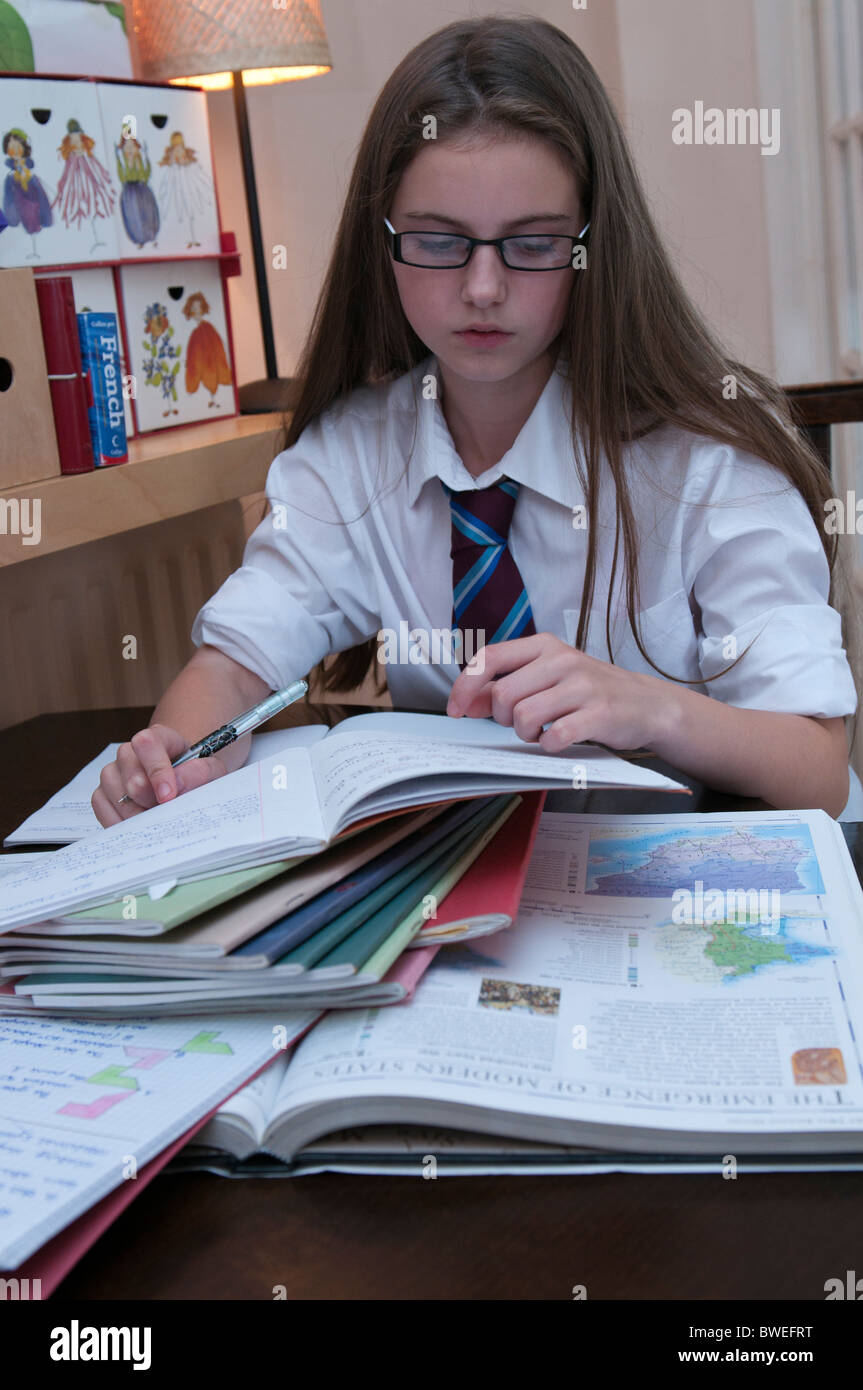 Jeune fille fait ses devoirs dans l'uniforme scolaire Banque D'Images