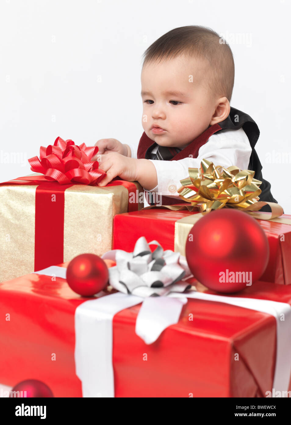 À l'âge de six mois, bébé garçon l'ouverture des cadeaux de Noël. Isolé sur  fond blanc Photo Stock - Alamy