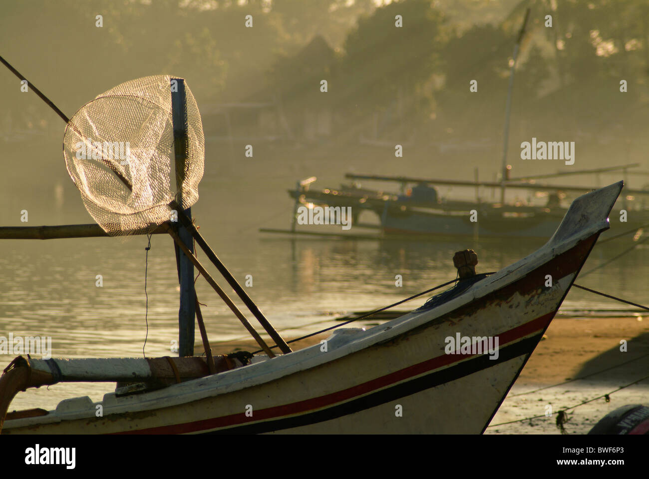 Dans la baie du village de pêcheurs de Pemuteran, Bali, les bateaux de pêche restent ancrées en attente de sortir dans la nuit pour la pêche. Banque D'Images