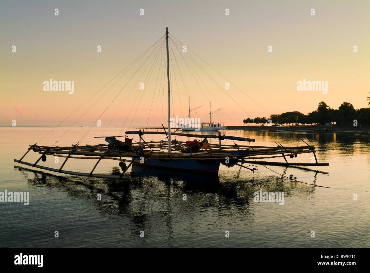 Dans la baie du village de pêcheurs de Pemuteran, Bali, les bateaux de pêche restent ancrées en attente de sortir dans la nuit pour la pêche. Banque D'Images