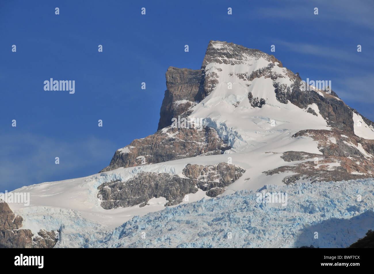 Pointe pyramidale couvertes de neige s'élevant au-dessus d'un glacier affluent vers l'Spegazzing fortement décroissant, des glaciers des Andes de Patagonie Banque D'Images