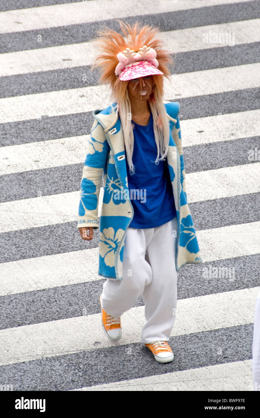 Un jeune homme portant des vêtements extravagants traverse une rue, Tokyo, Japon Banque D'Images