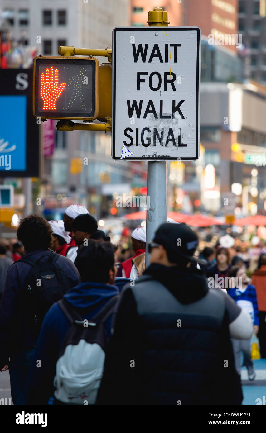 USA, New York, Manhattan, les gens à Times Square par passage piéton, signer avec une main rouge allumé pour arrêter Banque D'Images