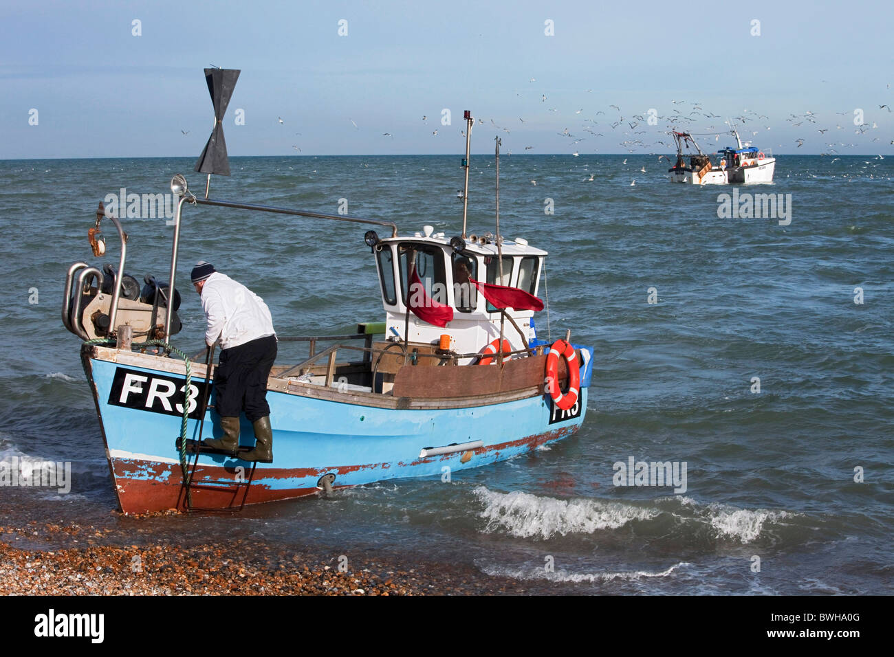 Les pêcheurs côtiers Jon Bailey et son fils Trevor lancer leur petit bateau le long de la plage de galets à Dungeness. DAVID MANSELL Banque D'Images