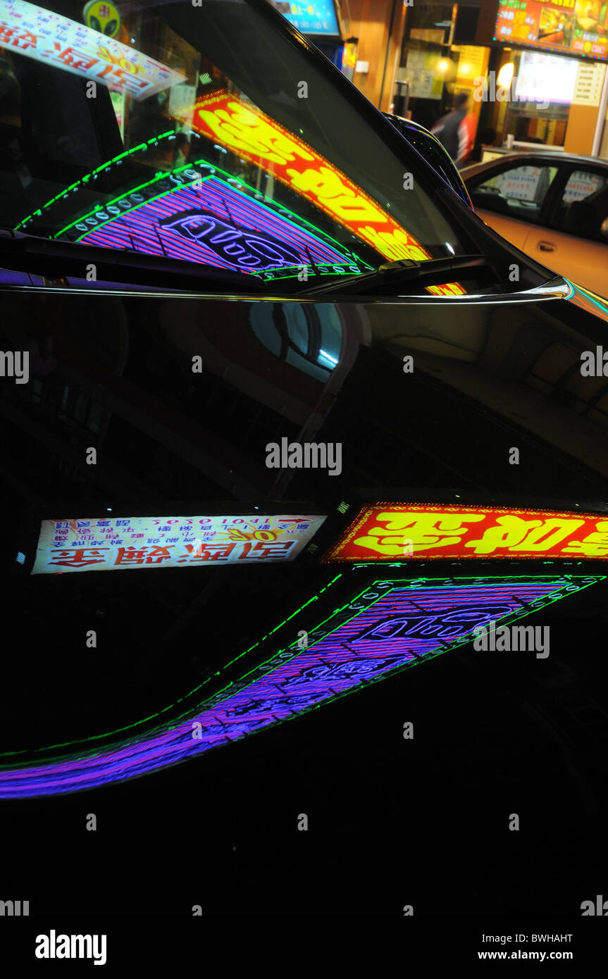 Hong Kongs lights reflète dans une voiture noire Banque D'Images