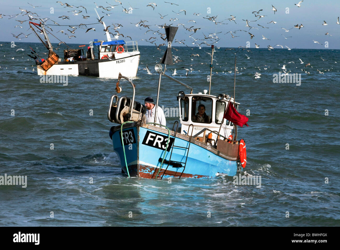 Les pêcheurs côtiers Jon Bailey et son fils Trevor, juste après avoir lancé leur bateau le long de la plage de galets à Dungeness. DAVID MANSELL Banque D'Images