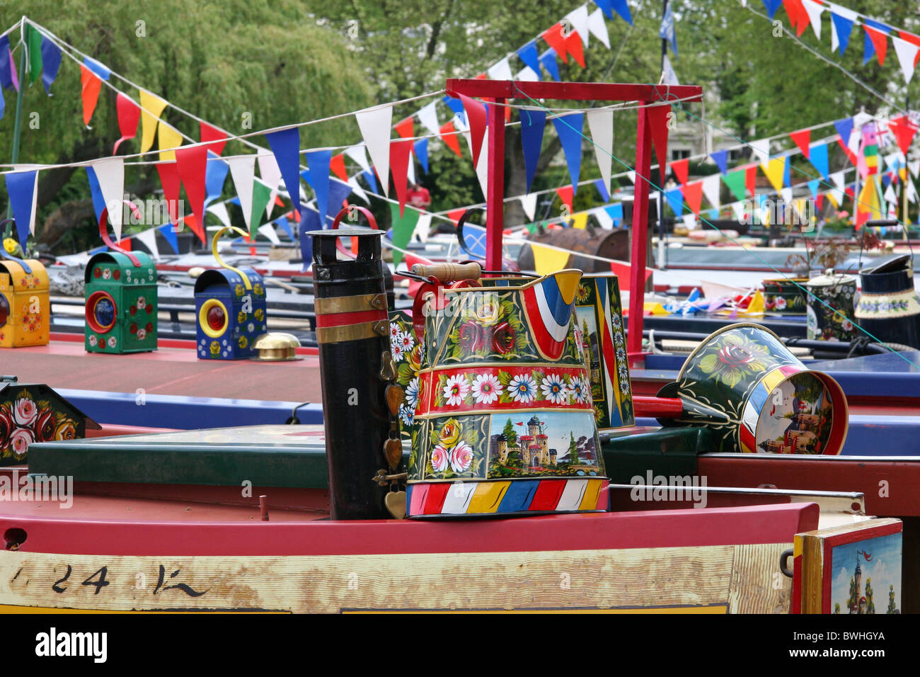 Vue sur bateaux étroits au festival dans la petite Venise barge peint ware y compris un buckby pouvez peint avec des roses et des châteaux Banque D'Images
