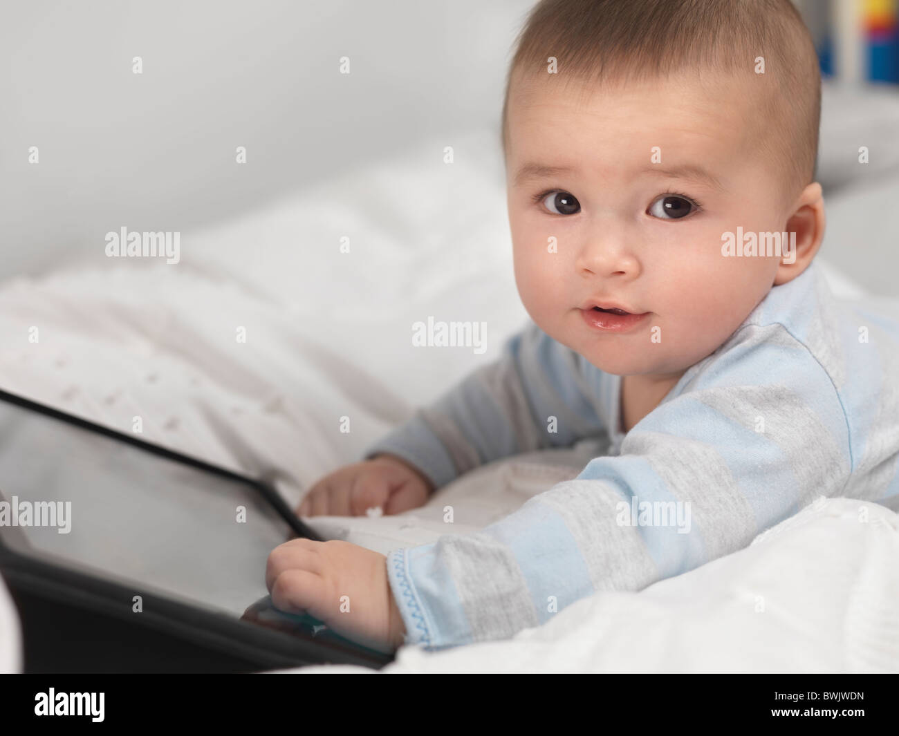 Six mois baby boy playing with a tablet computer Banque D'Images