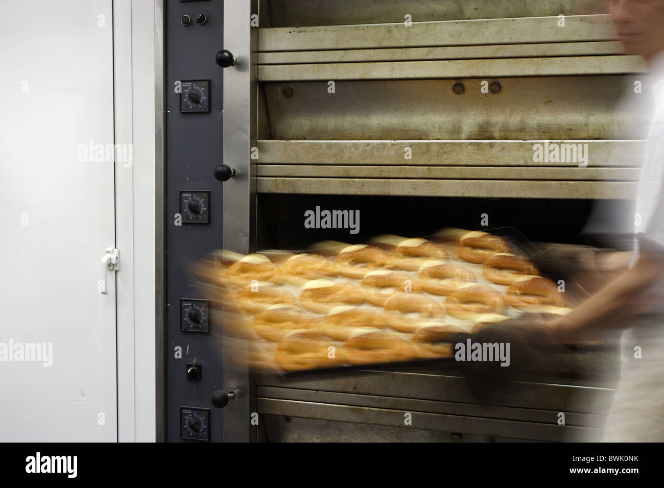 Un boulanger en tenant un plateau de bretzels sur un four à sole, Conil de la Frontera, Espagne Banque D'Images